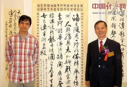 著名书画家郑碎孟(左)与台湾书法家吴肇勋(右)交流书画艺术并在吴肇勋书法作品前合影留念