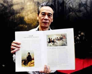 图为:刘柏荣展示载有他画作的图册 记者王永胜摄