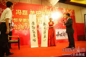 冯磊(右)向黄恒学(左)老师赠送书法作品《桃李满天下》 中国经济网记者李冬阳摄