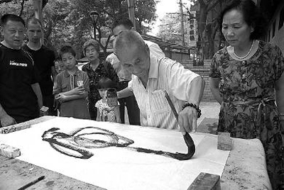 7月15日下午，李师傅在西安市书院门用左手横向写书法，一个大大的“虎”字跃然纸上，让人赞不绝口 摄友 宁旭忠 摄